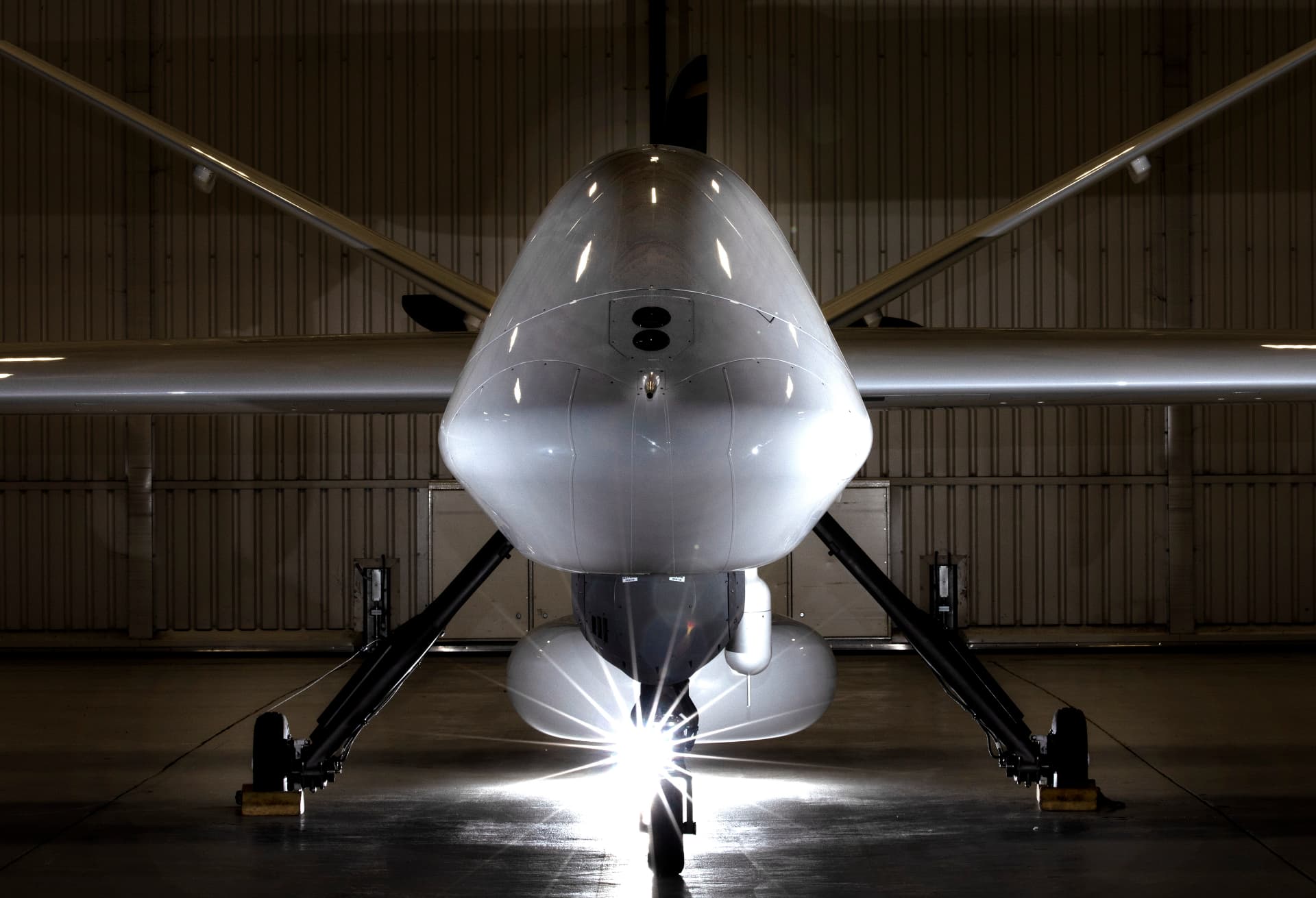 Uncrewed aircraft viewed from the front inside a hangar.