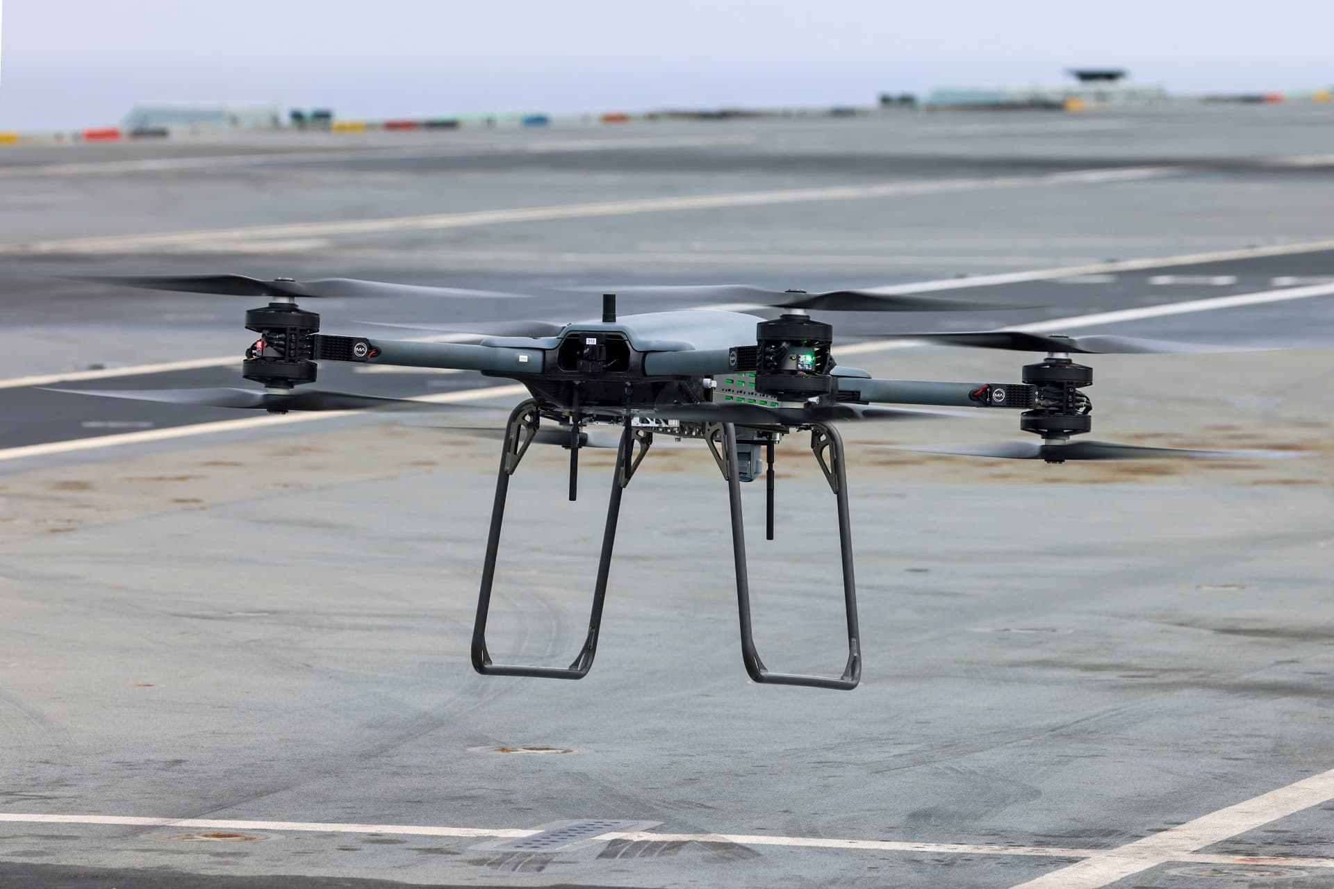Uncrewed rotor aircraft hovering outdoors.