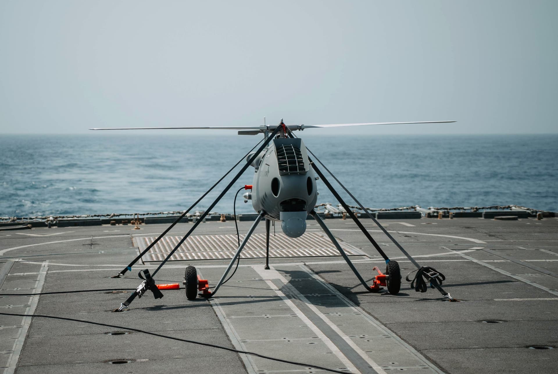 Uncrewed rotary aircraft on a naval flight deck.