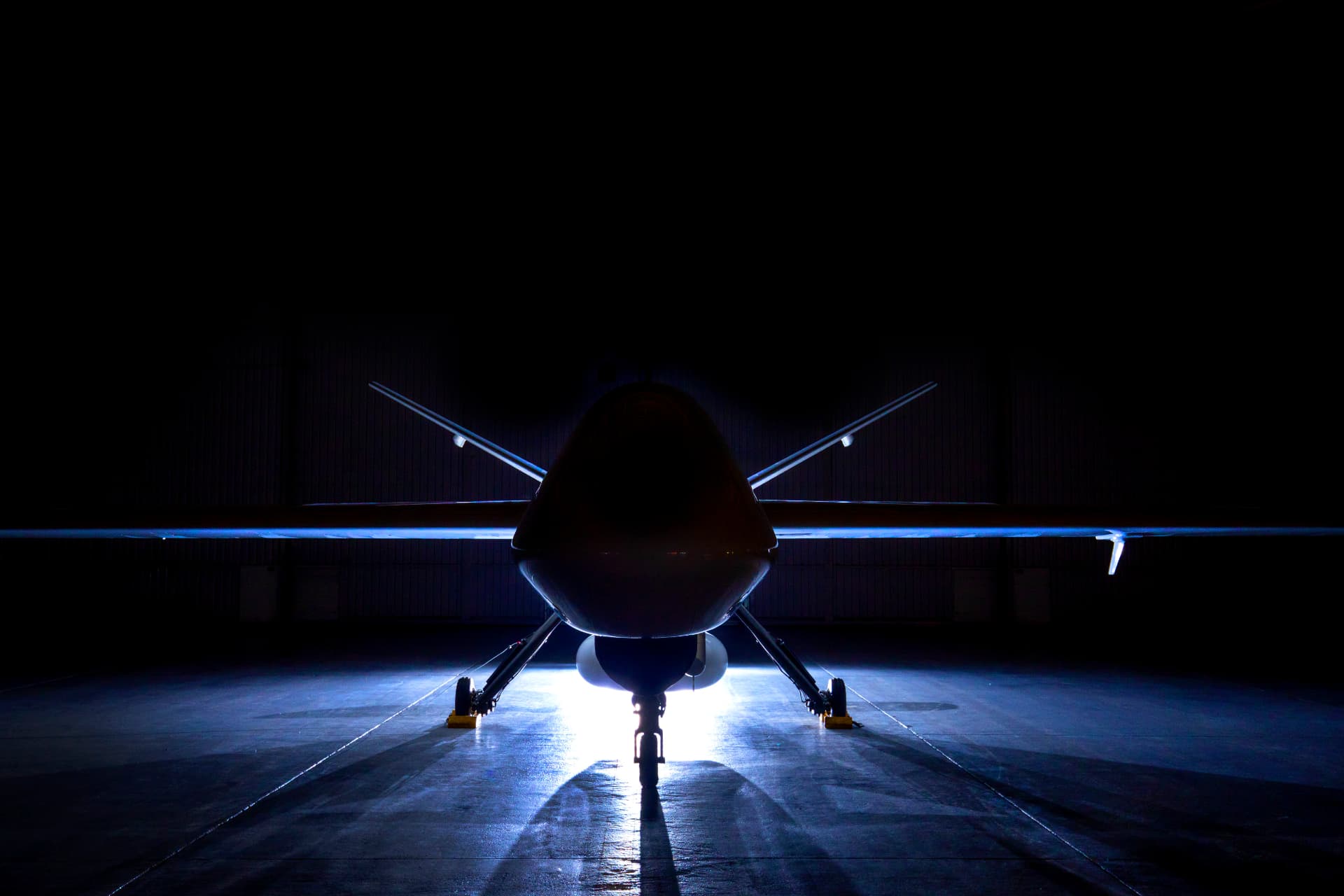 Long-endurance uncrewed aircraft photographed in a hangar at night.